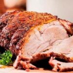 Venezuelan Christmas pernil, slow roasted pork leg sliced in its sauce