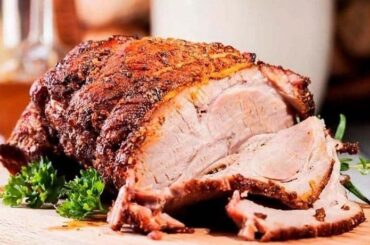 Venezuelan Christmas pernil, slow roasted pork leg sliced in its sauce