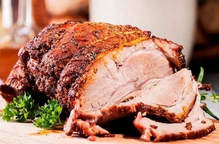 Venezuelan Christmas pernil, slow roasted pork leg sliced in its sauce