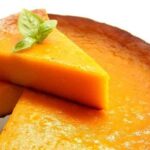 Freshly baked Venezuelan torta de auyama with a golden top, cut into portions
