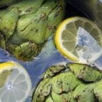 Artichoke water in a glass pitcher with lemon slices and mint