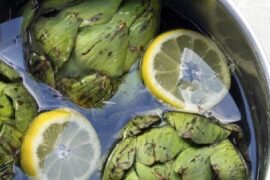 Artichoke water in a glass pitcher with lemon slices and mint