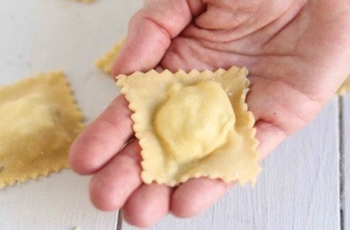 Assembling homemade ravioli with ham and ricotta filling