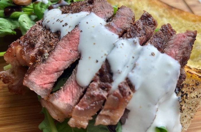 Creamy blue cheese sauce over grilled beef