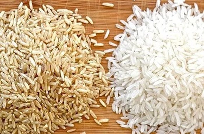 Brown rice next to white rice, showing the bran layer of whole grain rice