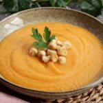 Carrot cream soup with croutons and parsley
