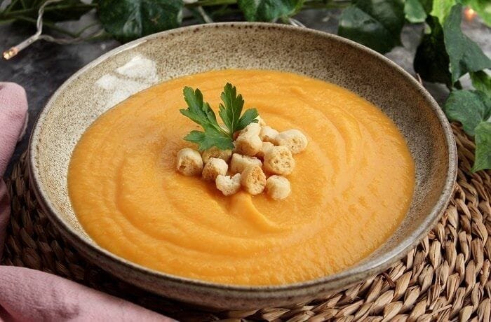 Carrot cream soup with croutons and parsley