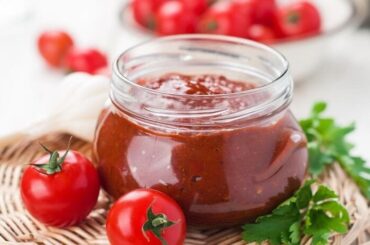 Homemade cherry tomato jam in a glass jar