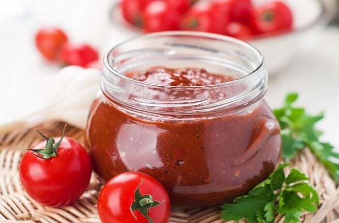 Homemade cherry tomato jam in a glass jar