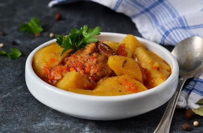 Chilean chicken stew with potatoes and carrots in tomato sauce