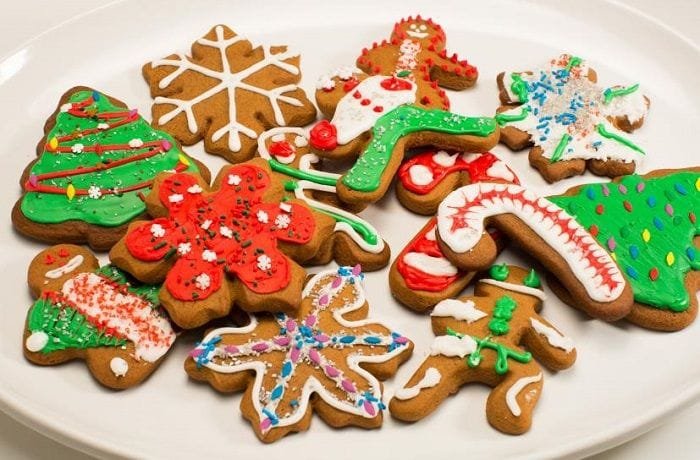 Chilean Christmas cookies cut into festive shapes and decorated with colored icing and sprinkles