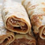 Chilean panqueques rolled with manjar and dusted with powdered sugar