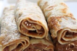 Chilean panqueques rolled with manjar and dusted with powdered sugar