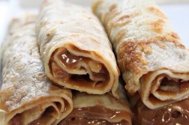Chilean panqueques rolled with manjar and dusted with powdered sugar