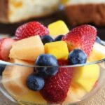 Chilean fresh fruit salad with strawberries, blueberries, apple, and orange topped with yogurt and honey