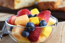 Chilean fresh fruit salad with strawberries, blueberries, apple, and orange topped with yogurt and honey