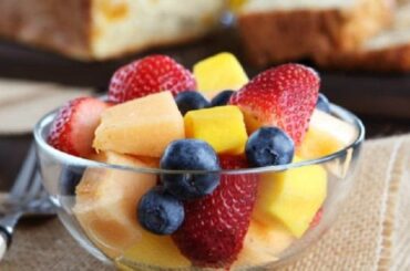 Chilean fresh fruit salad with strawberries, blueberries, apple, and orange topped with yogurt and honey