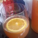 Chilean grape chicha with fresh orange juice served in a glass with an orange slice