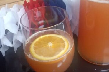 Chilean grape chicha with fresh orange juice served in a glass with an orange slice