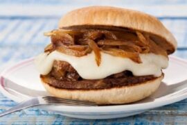 Chilean lamb sandwich with melted sheep cheese and sautéed onion in pan amasado