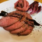 Chilean oven-roasted ribeye cut into pink slices for a holiday dinner
