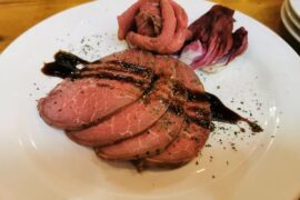 Chilean oven-roasted ribeye cut into pink slices for a holiday dinner