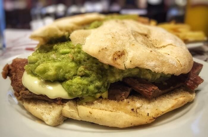 Chilean plateada sandwich with braised beef, mashed avocado, and mayonnaise in a marraqueta