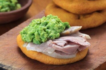 Chilean sandwich of sliced pork leg and mashed avocado between two sopaipillas