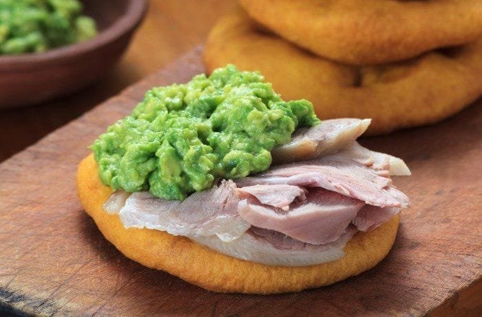 Chilean sandwich of sliced pork leg and mashed avocado between two sopaipillas