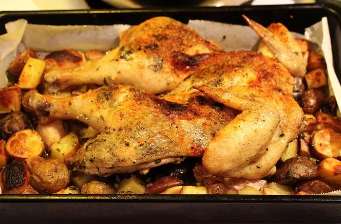 Chilean roast chicken with golden potatoes in a baking dish
