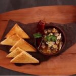 Chilean sea snails al pil pil with garlic and chili served in a clay bowl
