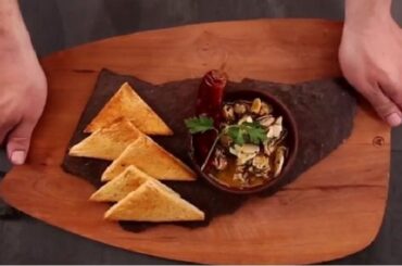 Chilean sea snails al pil pil with garlic and chili served in a clay bowl