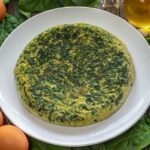 Chilean spinach omelette sliced in a skillet