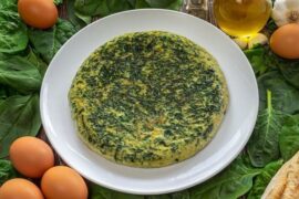 Chilean spinach omelette sliced in a skillet