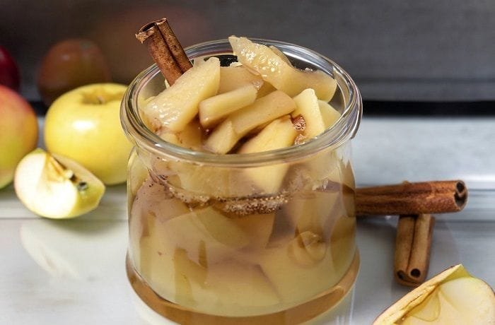 Chilean stewed apples with cinnamon served in dessert glasses with their cooking syrup