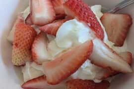 Chilean strawberries and cream served in a glass with whipped cream, a seasonal recipe