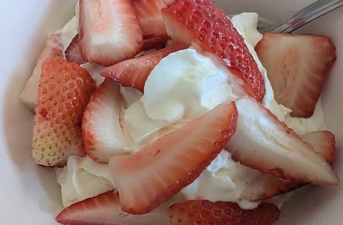 Chilean strawberries and cream served in a glass with whipped cream, a seasonal recipe