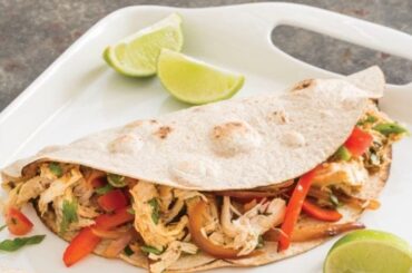Chicken fajitas with bell peppers and red onion in flour tortillas