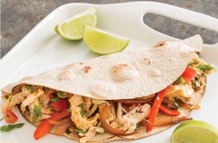 Chicken fajitas with bell peppers and red onion in flour tortillas