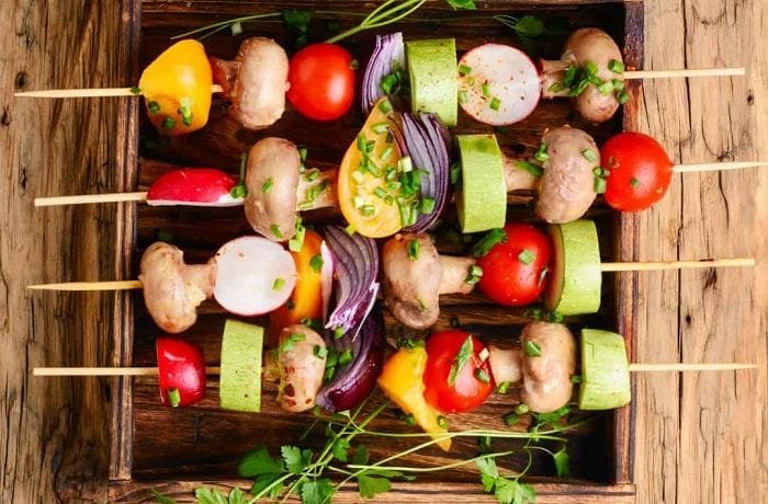 Chilean vegan anticuchos, grilled skewers of artichoke, mushrooms, cherry tomatoes, peppers, onion, and zucchini