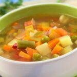 Chilean vegetable soup with potatoes, carrots, squash, and green beans, topped with cilantro