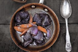 Chilean venison stew braised in red wine with carrots and pearl onions