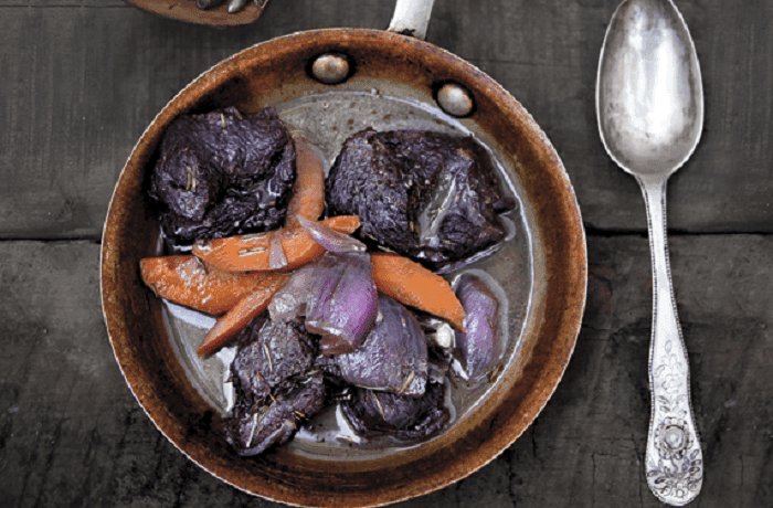 Chilean venison stew braised in red wine with carrots and pearl onions