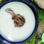 Chilote garlic cream soup topped with sautéed changle mushrooms in a clay bowl