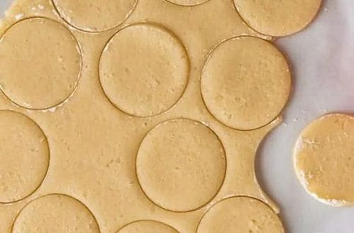Cutting butter cookies from rolled dough with a cookie cutter
