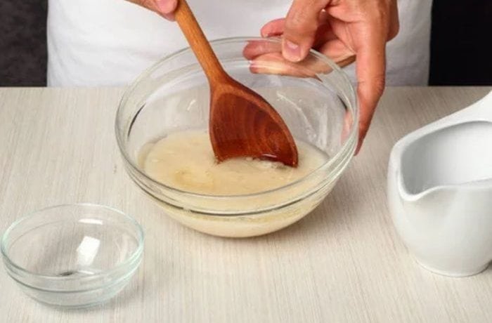 Dissolving fresh yeast in warm water for homemade pizza dough