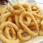 Crispy fried calamari rings with lemon wedges
