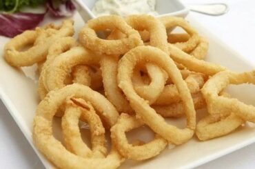 Crispy fried calamari rings with lemon wedges
