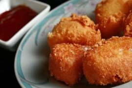 Breaded fried camembert wedges with sweet and sour sauce