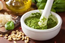 Homemade basil pesto in a mortar with pine nuts and parmesan